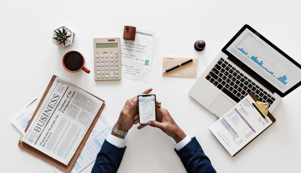 Businessman multitasking with a smartphone and laptop, engaged in professional activities
